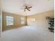 Large bedroom with neutral carpet, a ceiling fan, and three windows to provide great natural light at 9124 Topneck St, New Port Richey, FL 34654