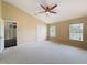 Large bedroom featuring neutral walls and carpet, two windows, and double door closet at 9124 Topneck St, New Port Richey, FL 34654