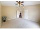 Carpeted bedroom with ceiling fan and en-suite bathroom with adjoining hallway at 9124 Topneck St, New Port Richey, FL 34654