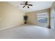 Large bedroom with a ceiling fan, neutral carpet, a big window, and plenty of natural light at 9124 Topneck St, New Port Richey, FL 34654