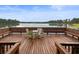 Scenic lake view from the wooden dock with benches and table set, perfect for relaxation at 9124 Topneck St, New Port Richey, FL 34654