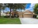 Charming single-story home with a well-manicured lawn, mature trees, and a spacious three-car garage at 9124 Topneck St, New Port Richey, FL 34654