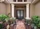 Elegant front entrance with decorative glass doors, columns, and lush landscaping at 9124 Topneck St, New Port Richey, FL 34654