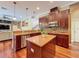 Open kitchen with center island, stainless steel appliances, and wood cabinetry at 9124 Topneck St, New Port Richey, FL 34654
