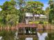 Picturesque view of the lake and clubhouse from the wooden dock, enhancing the natural beauty at 9124 Topneck St, New Port Richey, FL 34654