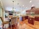 View of the gourmet kitchen, living room, and dining area showcasing the open layout and hardwood flooring at 9124 Topneck St, New Port Richey, FL 34654