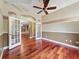 Bright living room with hardwood floors, ceiling fan, and double-door access to another area at 9124 Topneck St, New Port Richey, FL 34654