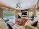 Open living room featuring sliding glass doors to the pool and plush furnishings at 9124 Topneck St, New Port Richey, FL 34654