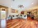 Open living room with hardwood floors flows into the dining and kitchen areas with neutral décor and recessed lighting at 9124 Topneck St, New Port Richey, FL 34654