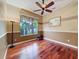 Well-lit home office boasts hardwood floors, neutral paint, and natural light from a large window at 9124 Topneck St, New Port Richey, FL 34654