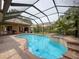 Relaxing backyard with a large screened-in pool, spa, and a brick patio at 9124 Topneck St, New Port Richey, FL 34654