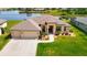 Aerial view of a charming home overlooking a serene pond with lush greenery and luxurious landscaping in the backyard at 9125 Palm Beach Dr, Brooksville, FL 34613