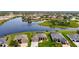 An aerial view showcasing multiple homes in a residential area next to a serene lake and beautiful green areas at 9125 Palm Beach Dr, Brooksville, FL 34613