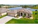 Aerial view of home with attached garages and scenic backyard pond, surrounded by greenery, and lush landscaping at 9125 Palm Beach Dr, Brooksville, FL 34613