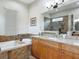 This bathroom features granite counters, wood cabinets, a soaking tub, and a large mirror at 9125 Palm Beach Dr, Brooksville, FL 34613