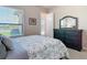 Bedroom with view of lake from window and dresser with mirror at 9125 Palm Beach Dr, Brooksville, FL 34613