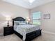 Bedroom featuring a black sleigh bed, two side tables, and a window view of the water at 9125 Palm Beach Dr, Brooksville, FL 34613