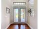 Elegant foyer featuring double doors with transom window and hardwood floors, creating a warm entrance at 9125 Palm Beach Dr, Brooksville, FL 34613