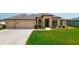 Beautifully landscaped yard with a circular driveway and a charming two-story home with neutral exteriors at 9125 Palm Beach Dr, Brooksville, FL 34613