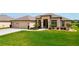 Well manicured green lawn in front of a well maintained home with a brick paver driveway and attached garage at 9125 Palm Beach Dr, Brooksville, FL 34613