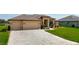 Charming curb appeal featuring an inviting front yard with stone paver driveway and attached two car garage at 9125 Palm Beach Dr, Brooksville, FL 34613