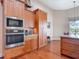 Kitchen with stainless steel oven, microwave and wooden cabinets with granite countertops at 9125 Palm Beach Dr, Brooksville, FL 34613