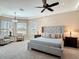 This main bedroom features neutral walls, a ceiling fan, tray ceiling and comfortable furnishings at 9125 Palm Beach Dr, Brooksville, FL 34613