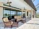 Inviting covered patio with brick flooring and comfortable wicker furniture, perfect for outdoor relaxation and entertaining at 9125 Palm Beach Dr, Brooksville, FL 34613