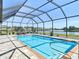 Relax by the pool in the screened-in lanai, offering stunning lake views and a perfect spot for outdoor fun at 9125 Palm Beach Dr, Brooksville, FL 34613
