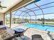 Inviting screened pool area, complete with stylish furniture and picturesque views of the tranquil lake at 9125 Palm Beach Dr, Brooksville, FL 34613