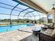 Enjoy the screened pool area with comfortable seating and beautiful lake views for relaxation and entertainment at 9125 Palm Beach Dr, Brooksville, FL 34613