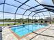 Sparkling swimming pool enclosed with a screen, complemented by lounge chairs and lush greenery, creating a resort-like atmosphere at 9125 Palm Beach Dr, Brooksville, FL 34613