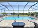 A screened pool area offers a refreshing escape with its serene lake backdrop and inviting lounge spaces at 9125 Palm Beach Dr, Brooksville, FL 34613