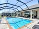 Inviting screened-in pool with brick surround, lounge chairs, and an outdoor patio, perfect for entertaining and relaxation at 9125 Palm Beach Dr, Brooksville, FL 34613