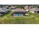 Aerial shot of screened-in pool in backyard; landscaped yard with green grass at 9125 Palm Beach Dr, Brooksville, FL 34613