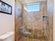 Close up of tiled shower with glass door and built-in niche shelf at 9125 Palm Beach Dr, Brooksville, FL 34613