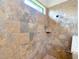 This shower features stone-look tile, a window for light, and a rain shower head at 9125 Palm Beach Dr, Brooksville, FL 34613