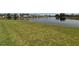 Scenic water view with lush green space and residences located directly on the community lake at 9125 Palm Beach Dr, Brooksville, FL 34613