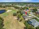 Aerial view of a home backing onto a golf course with a pond, surrounded by lush landscaping and residential properties at 9216 Tarleton Cir, Weeki Wachee, FL 34613