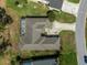 An aerial view of a home's roof featuring a screened-in lanai with a spa, lush landscaping, and a lengthy driveway at 9216 Tarleton Cir, Weeki Wachee, FL 34613