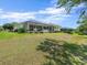 Expansive backyard with a screened-in lanai, lush lawn, and mature landscaping at 9216 Tarleton Cir, Weeki Wachee, FL 34613