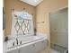 Bright bathroom boasts a soaking tub beneath a decorative window and a separate shower at 9216 Tarleton Cir, Weeki Wachee, FL 34613