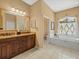 Bathroom with double vanity, granite countertops, and a separate tub, offering a spa-like experience at 9216 Tarleton Cir, Weeki Wachee, FL 34613