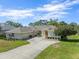 Inviting home featuring a spacious three-car garage, double-door entry, and pristine landscaping at 9216 Tarleton Cir, Weeki Wachee, FL 34613