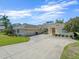 Elegant home boasting a three-car garage, vibrant green lawn, and inviting double-door entry at 9216 Tarleton Cir, Weeki Wachee, FL 34613