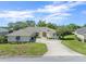 Charming single-story home with a well-manicured lawn, mature trees, and a double-door entrance at 9216 Tarleton Cir, Weeki Wachee, FL 34613