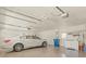 Spacious two-car garage featuring epoxy flooring, storage cabinets, utility sink, and car at 9216 Tarleton Cir, Weeki Wachee, FL 34613