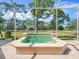 In-ground spa in a screened in lanai, surrounded by lush landscaping and a view of the golf course at 9216 Tarleton Cir, Weeki Wachee, FL 34613