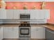 Bright kitchen with stainless steel appliances, granite countertops, and white cabinets at 9216 Tarleton Cir, Weeki Wachee, FL 34613