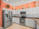 Bright kitchen with stainless steel appliances, granite countertops, and white cabinets at 9216 Tarleton Cir, Weeki Wachee, FL 34613